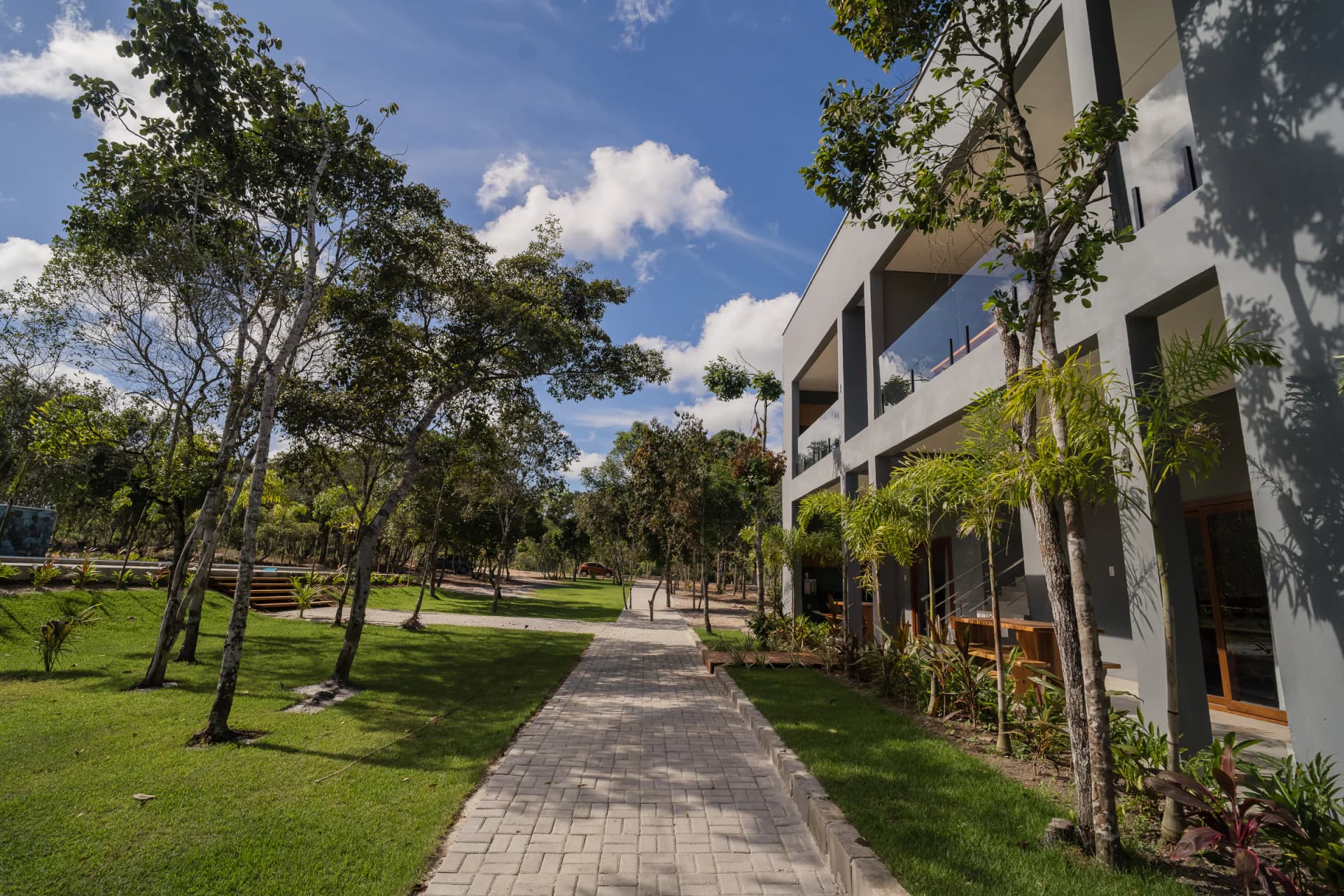 Caminho arborizado junto aos apartamentos no Residencial Marinho, Arraial d’Ajuda.