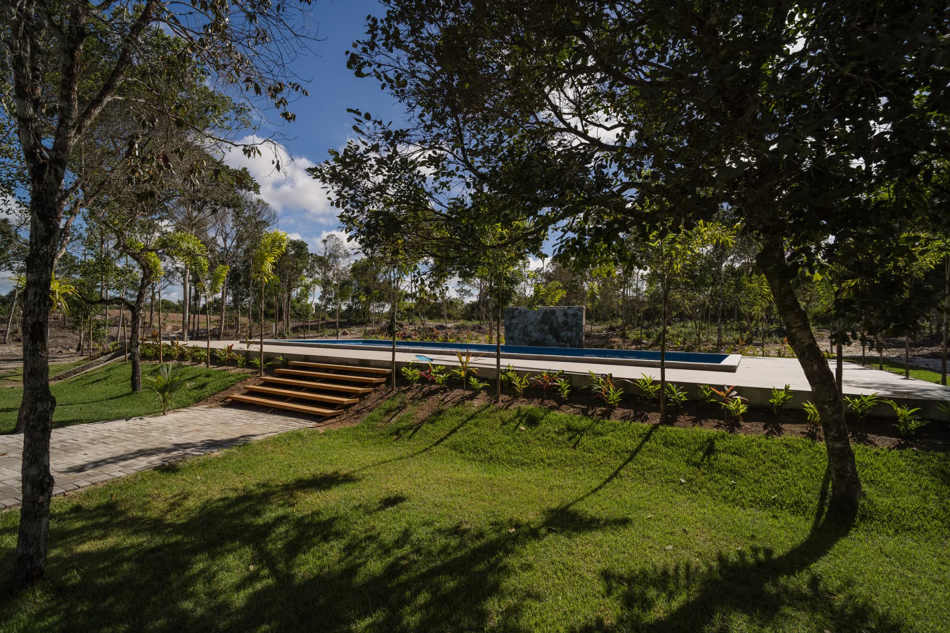 Gramado e deck cercados pela vegetação no Residencial Marinho, Arraial d’Ajuda.