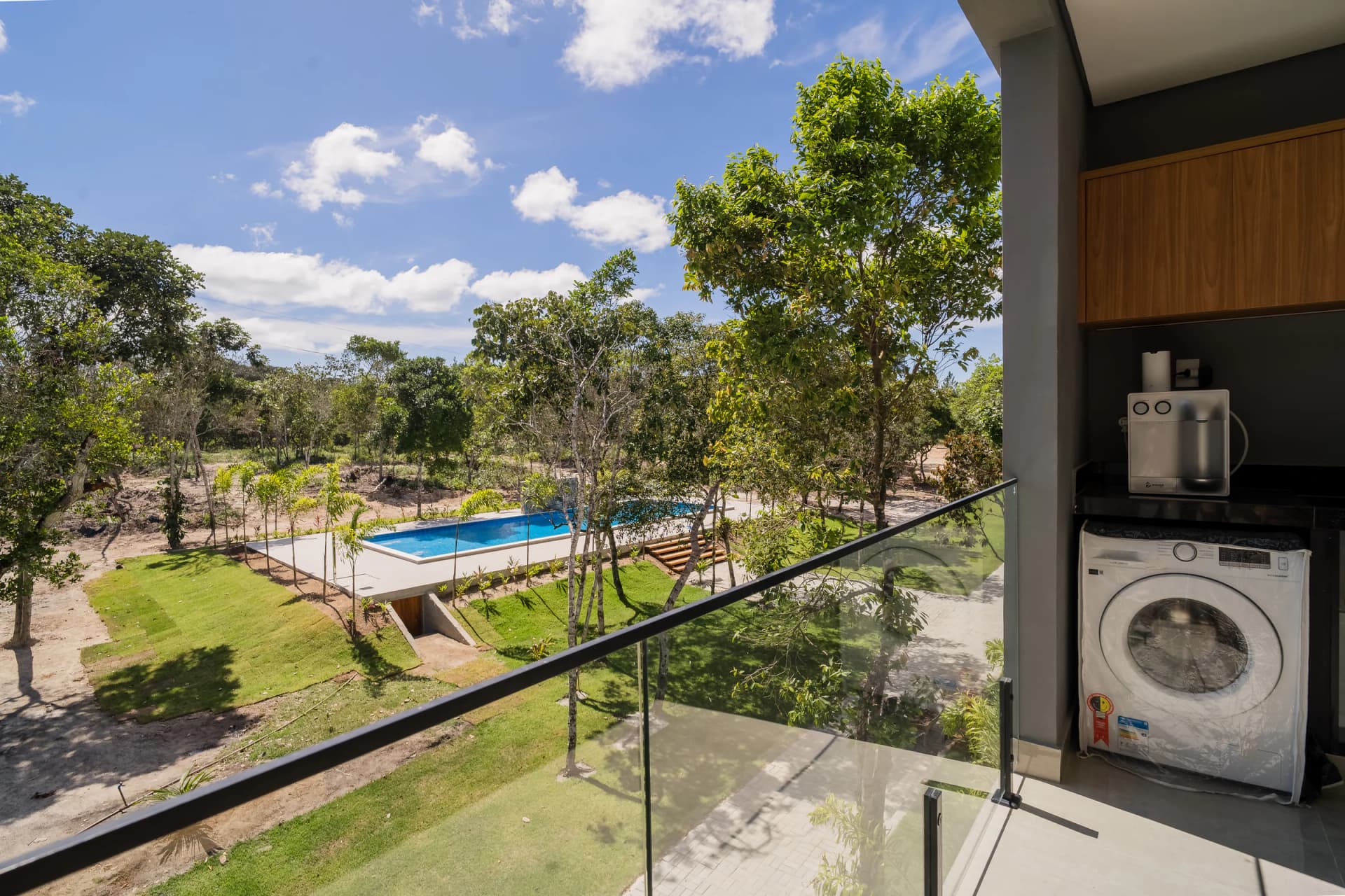 Vista da varanda para o jardim e a piscina no Residencial Marinho, Arraial d’Ajuda.