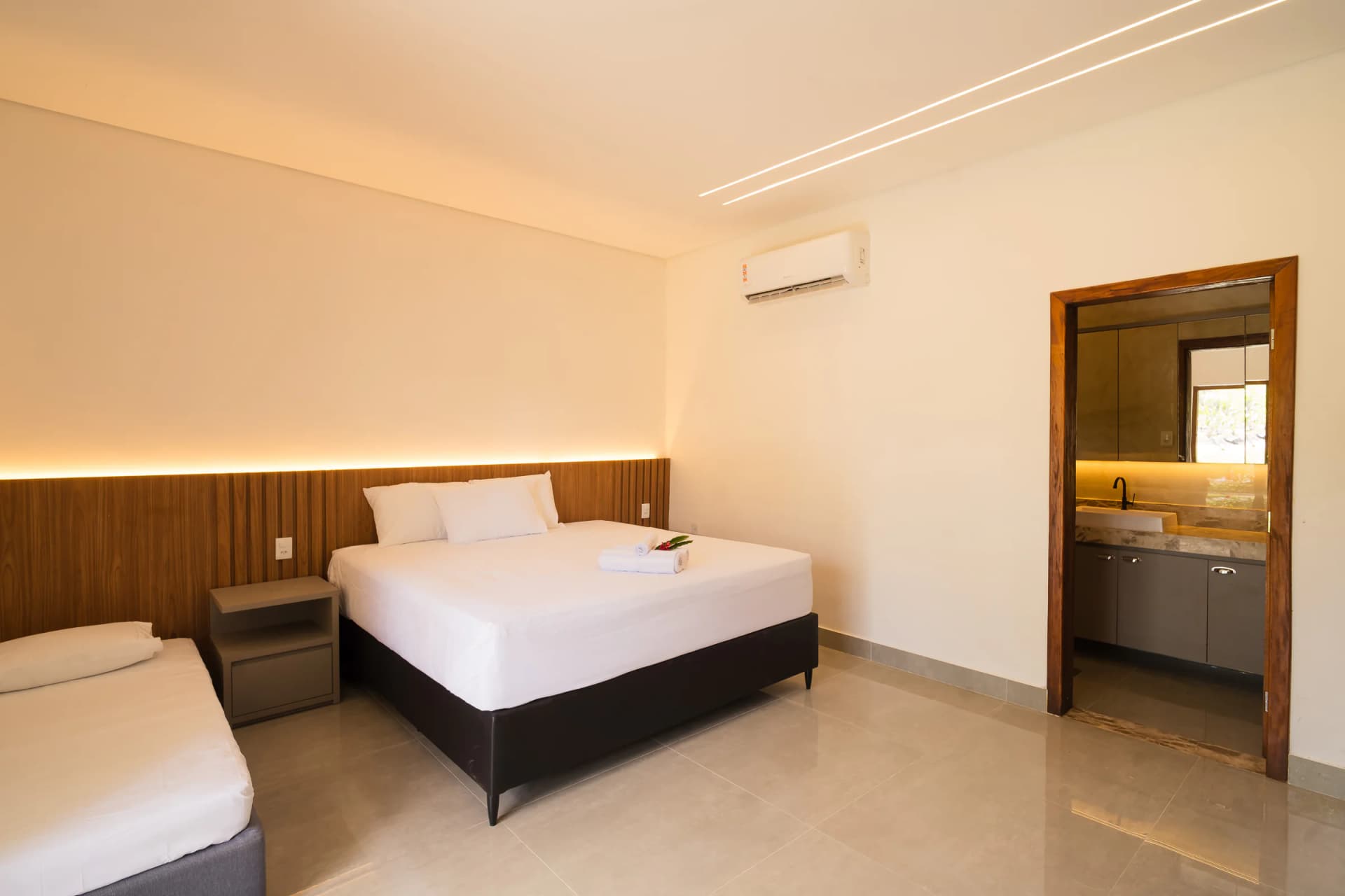 Cama e passagem para o banheiro no Residencial Marinho, Arraial d’Ajuda.