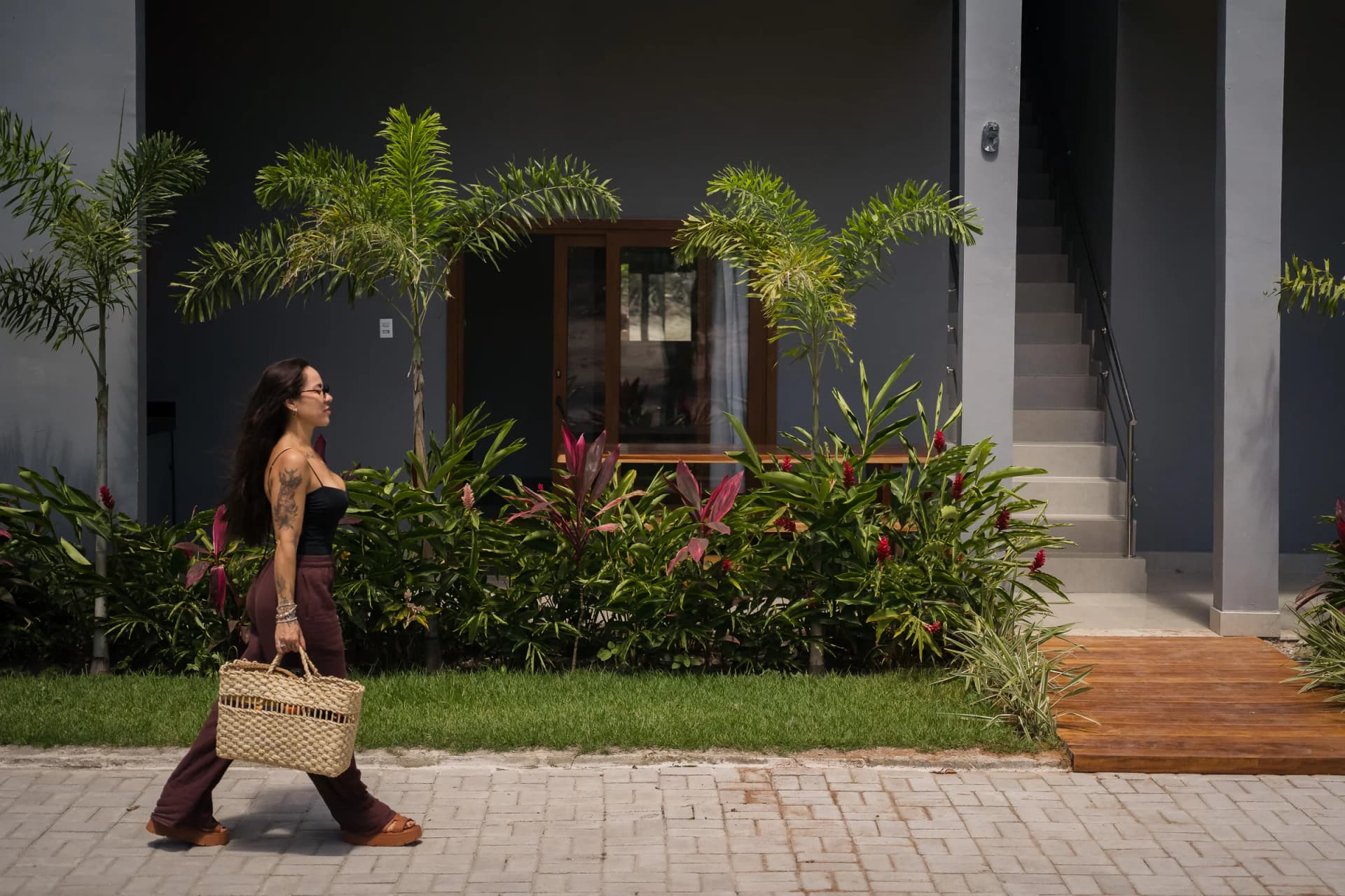 Pessoa caminhando diante das suítes no Residencial Marinho, Arraial d’Ajuda.