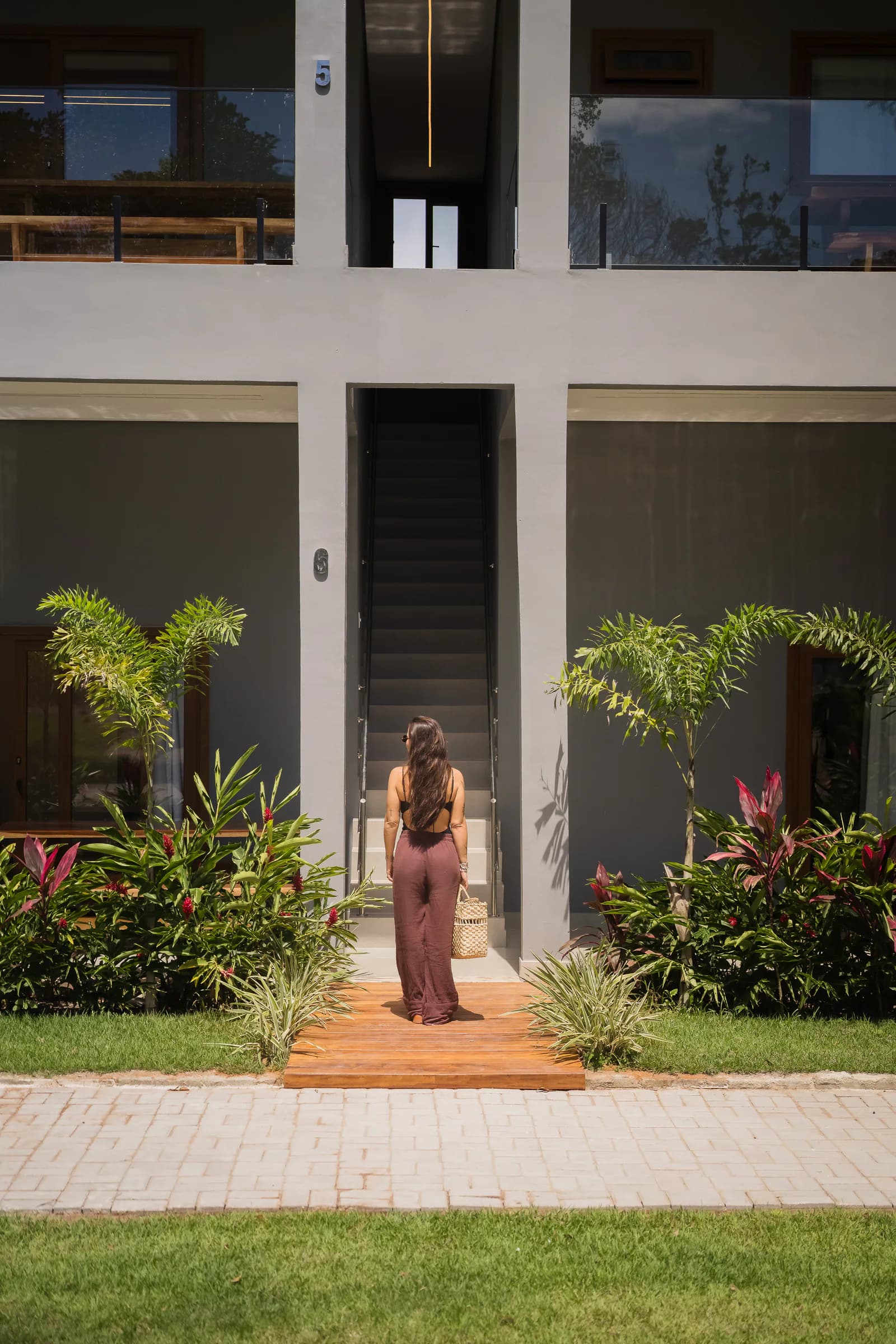 Pessoa na entrada de uma suíte no Residencial Marinho, Arraial d’Ajuda.